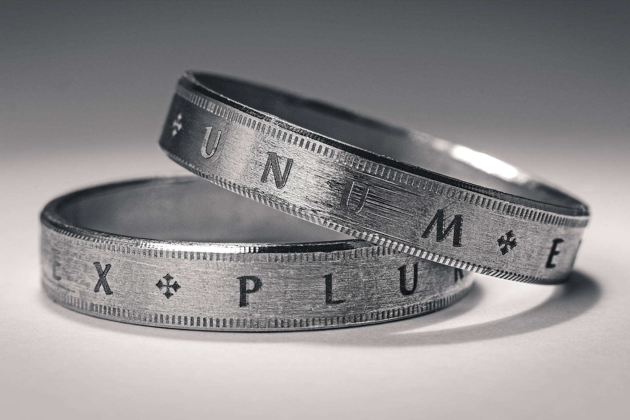macro photo of two rings with latin words engraved