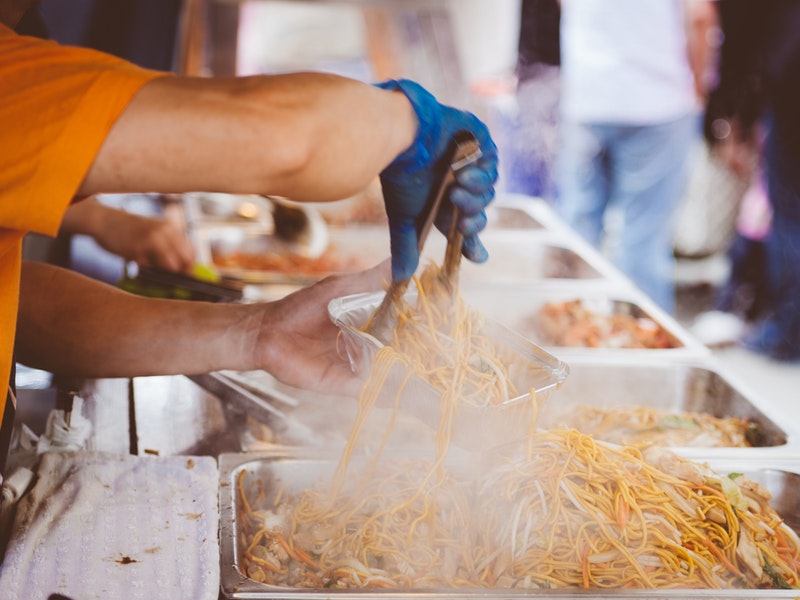 man's arms serving pumpkin french fries at festival