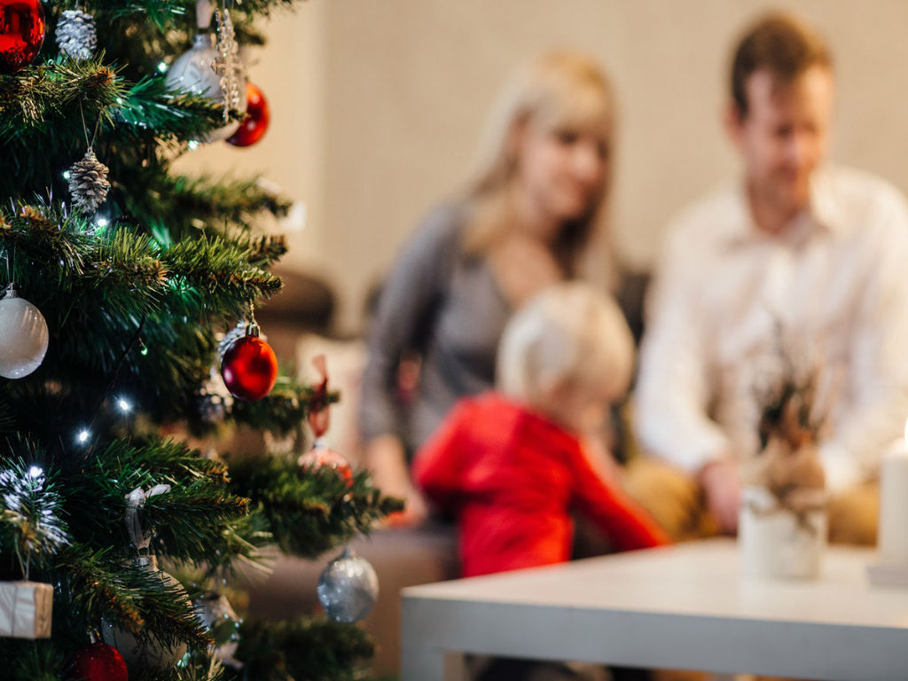 family gathered by a christmas tree