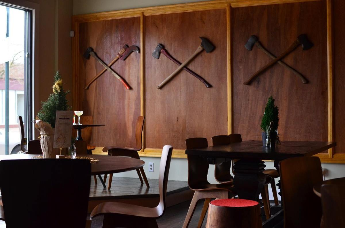 dining tables and axes displayed on the wall at overlook odge