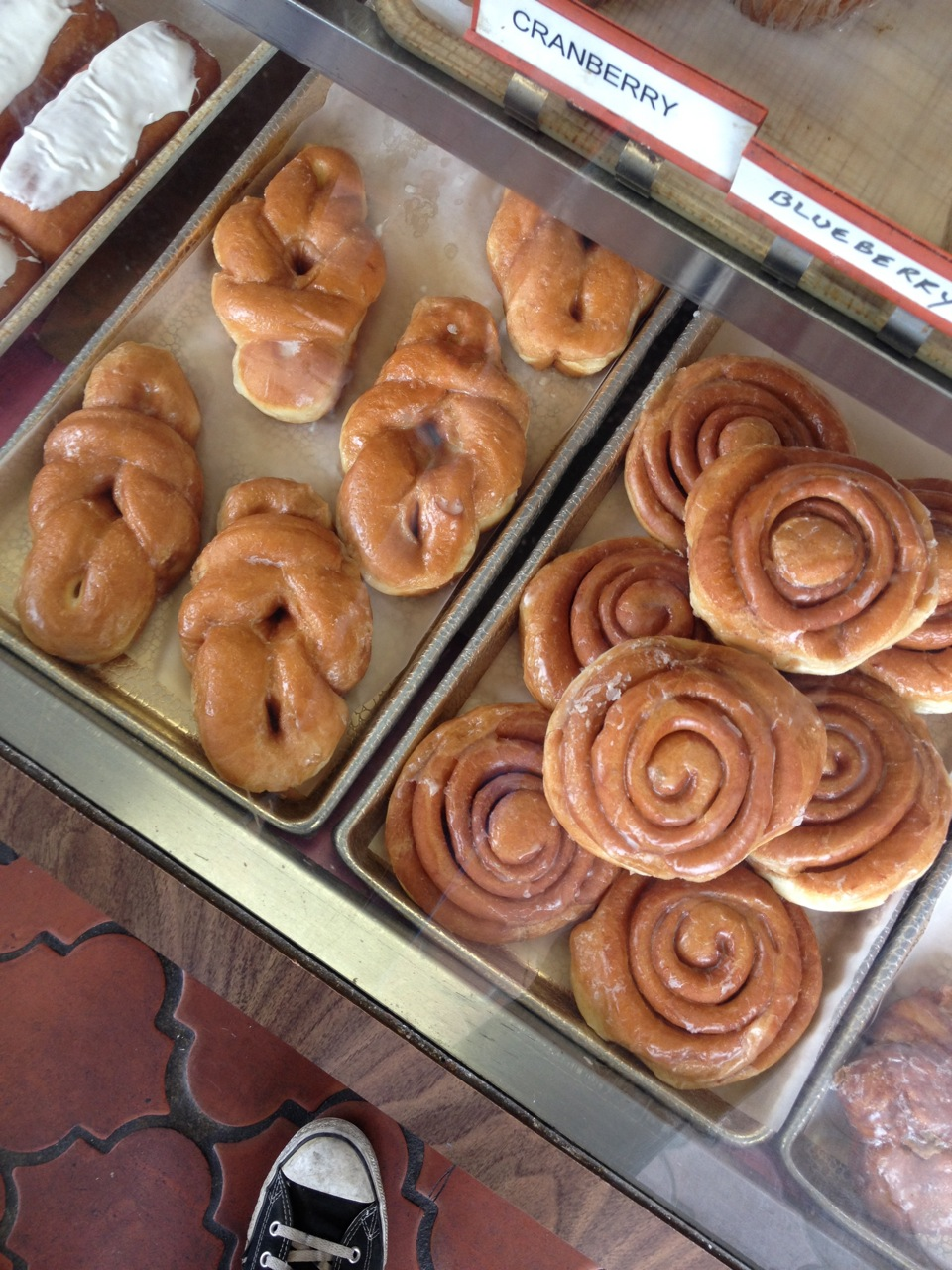 cinnamon rolls and other pastries behind glass
