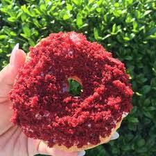 hand holding strawberry glazed donut