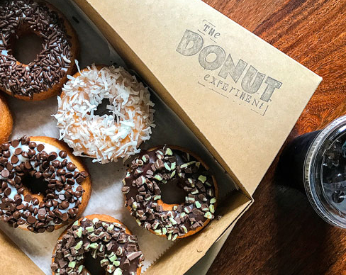 box of glazed donuts with chocolate toppings