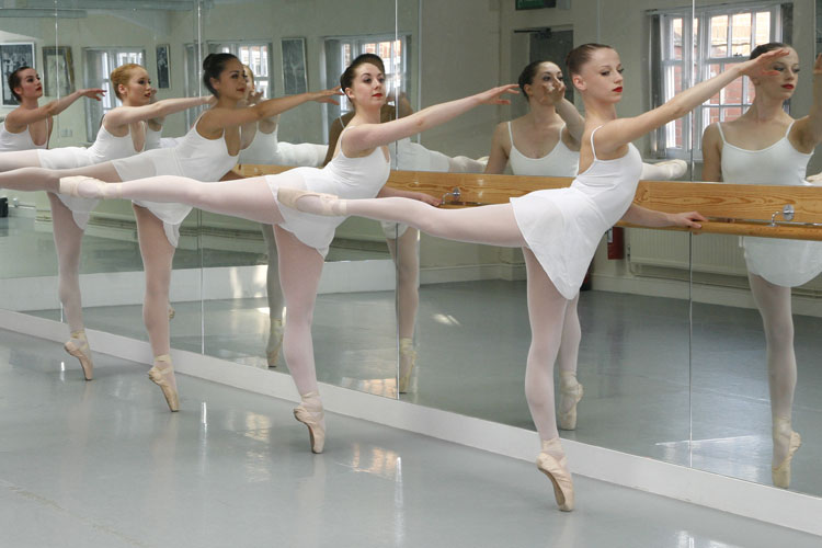 ballerinas stretching next to a mirror