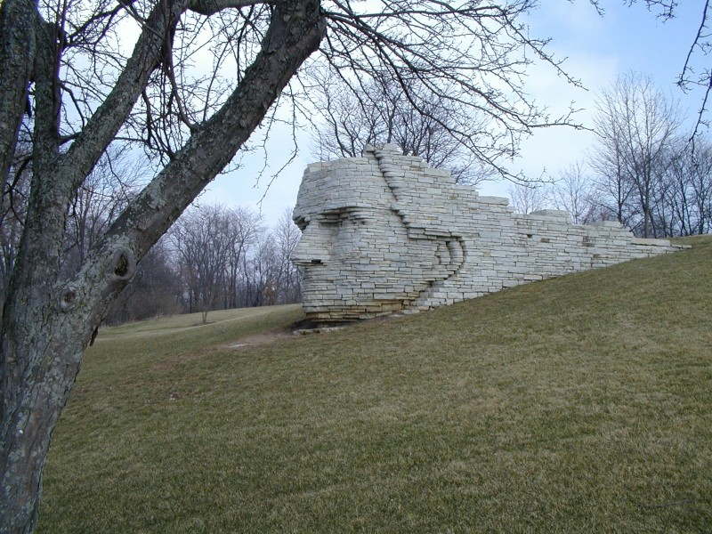 a white brick sculpture of chief leather lips set into a hillside in dublin ohio