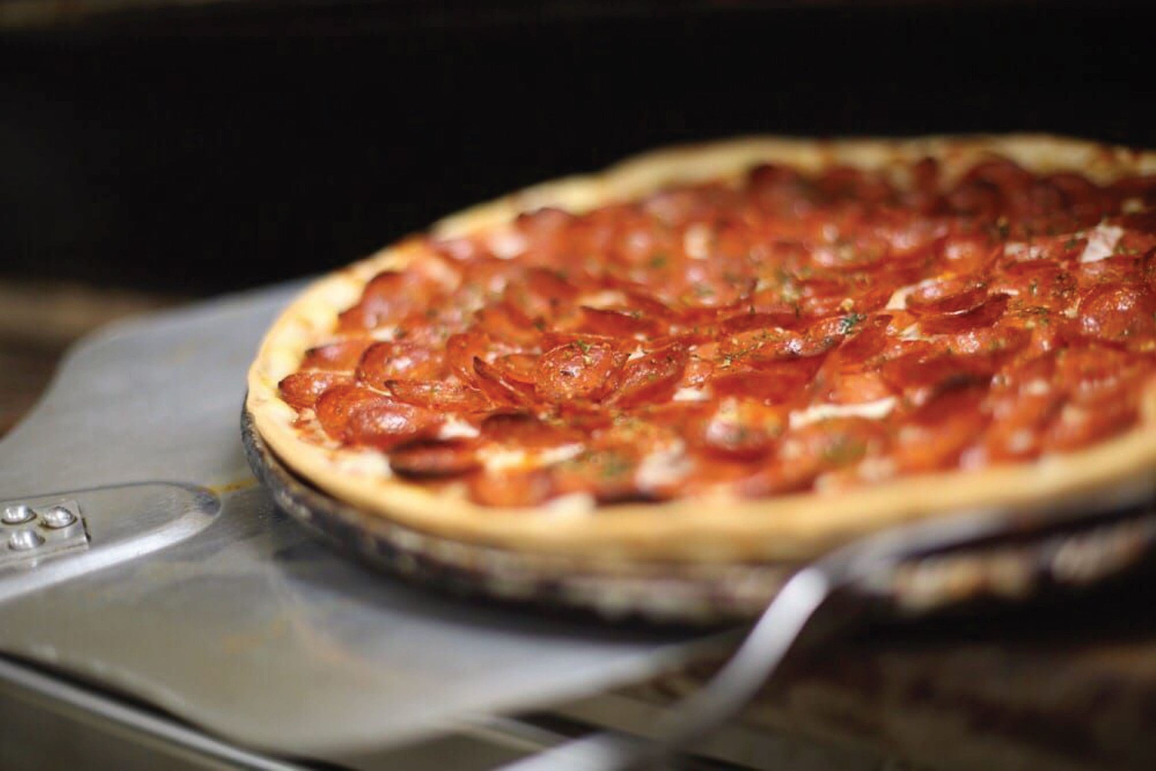 Extra pepperoni pizza coming out of the oven