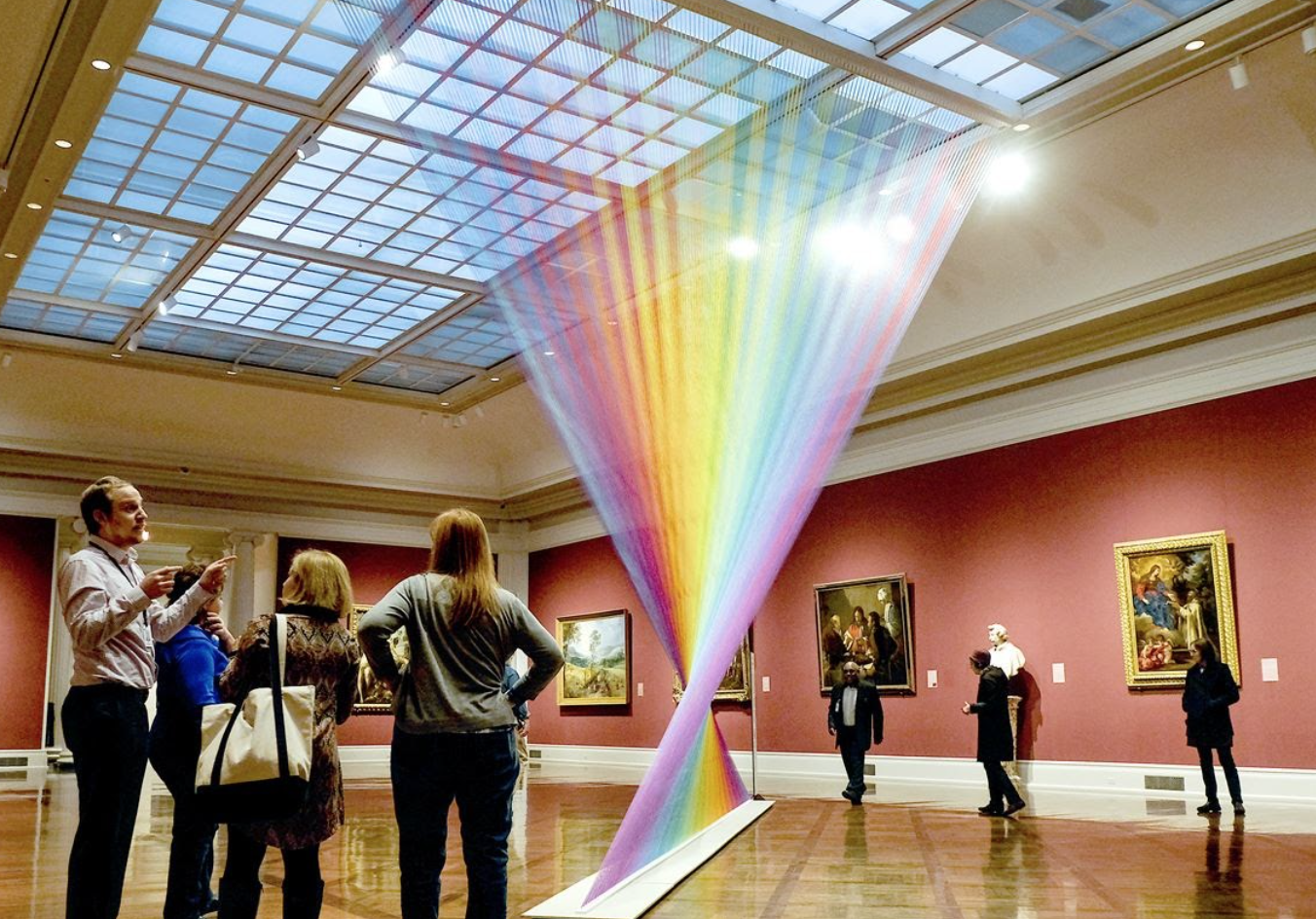 people gather around an exhibit at an art museum in toledo
