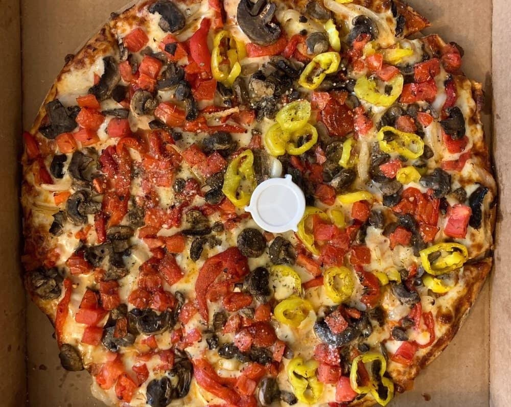 Pizza half shrooms and tomatoes half banana peppers