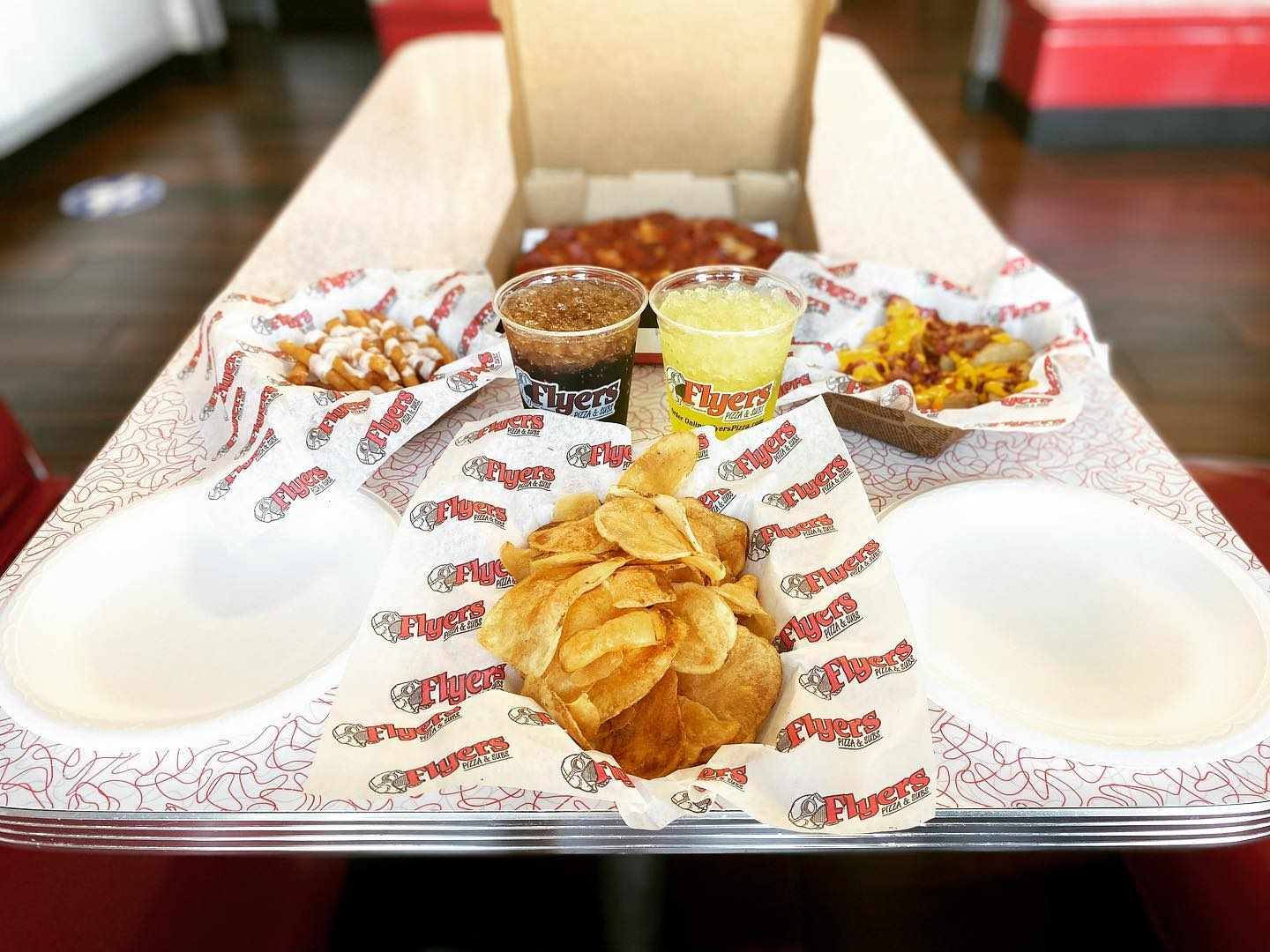 Table with chips, pizza, and drinks