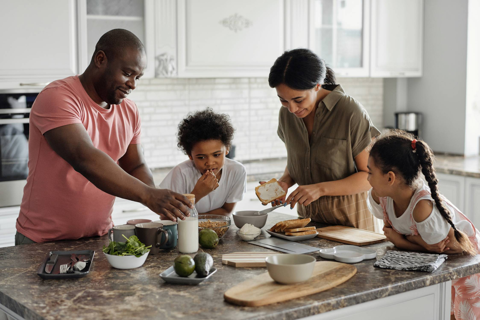 family at kitchen island making breakfast