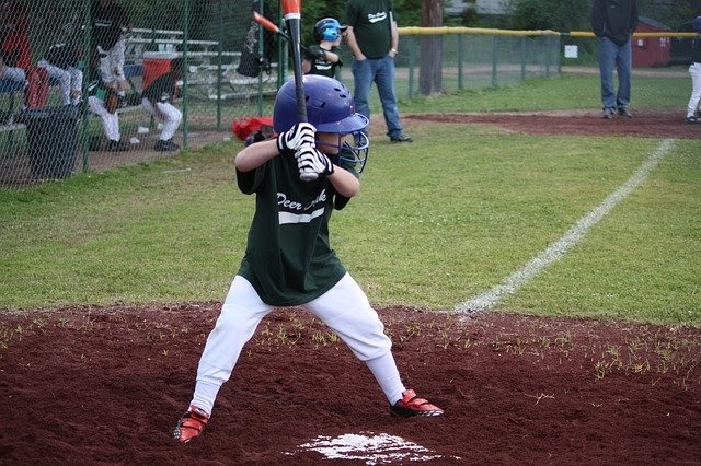 a child outdoors up to bat