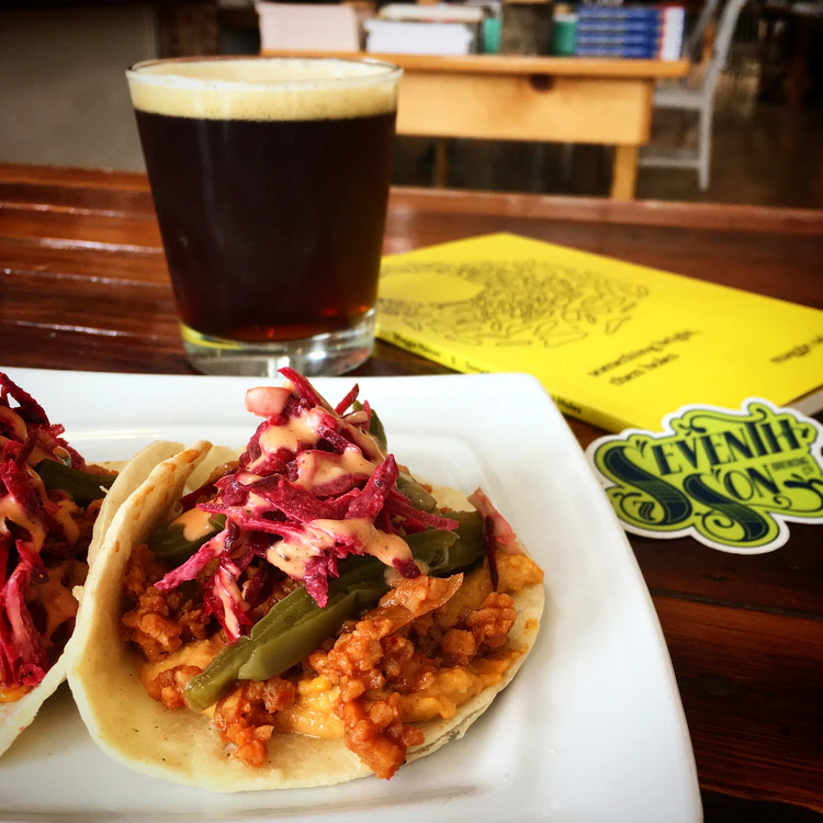 Taco on White Plate with glass of Coffee and a Book