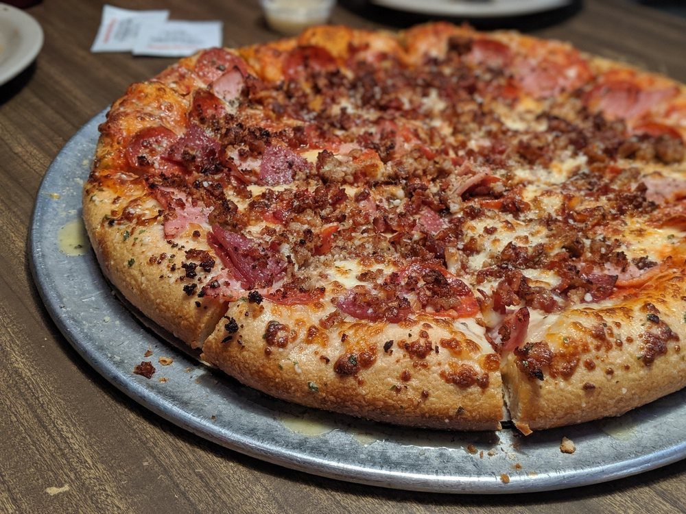pizza with sausage, bacon, pepperoni, and ham