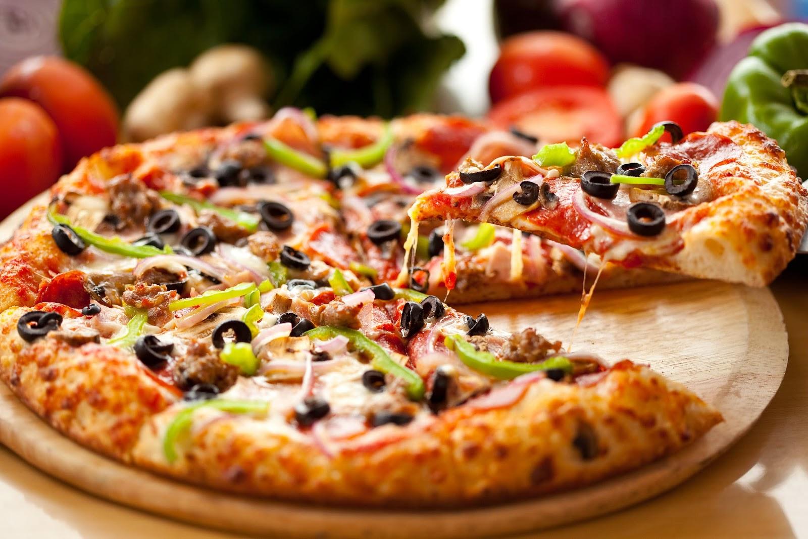 Delicious slice of pizza being removed from a fresh pie