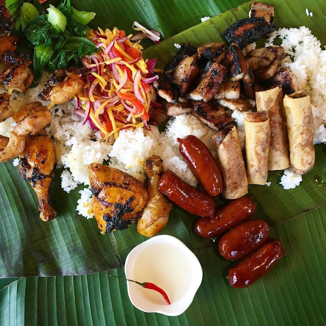 Filipino food spread chicken slaw and banana leaves