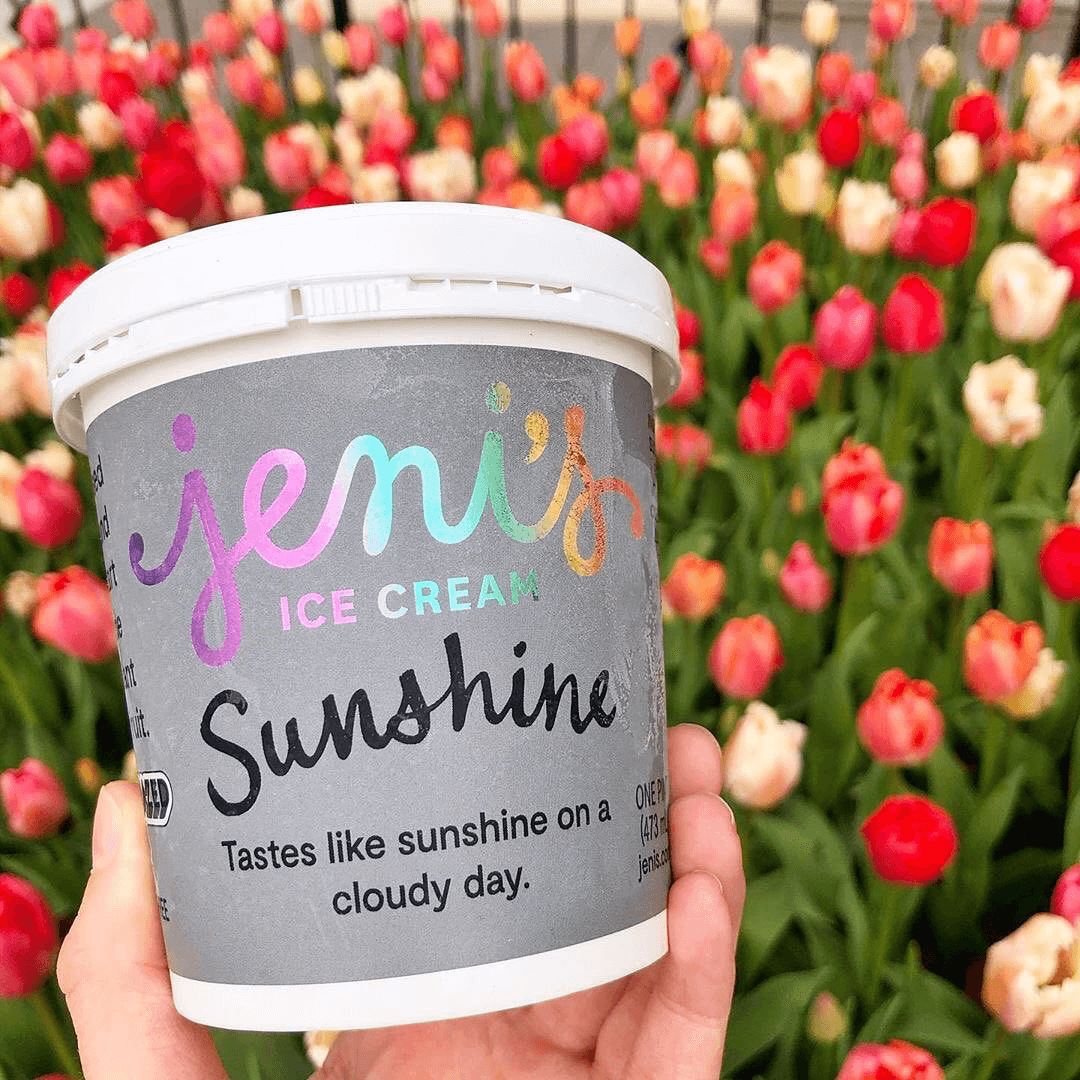 A carton of ice cream in front of a field of tulips.