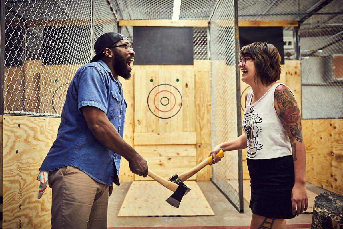 A couple have fun at an ax-throwing facility