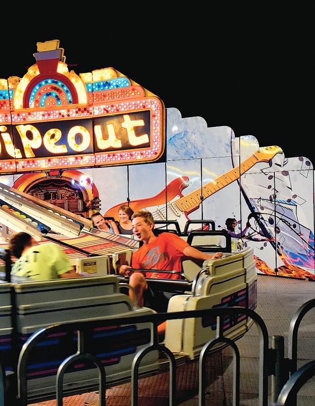 young boy riding a carnival roller coaster