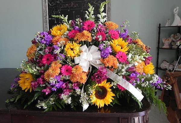 Floral arrangement of sunflowers, pink flowers, and purple flowers