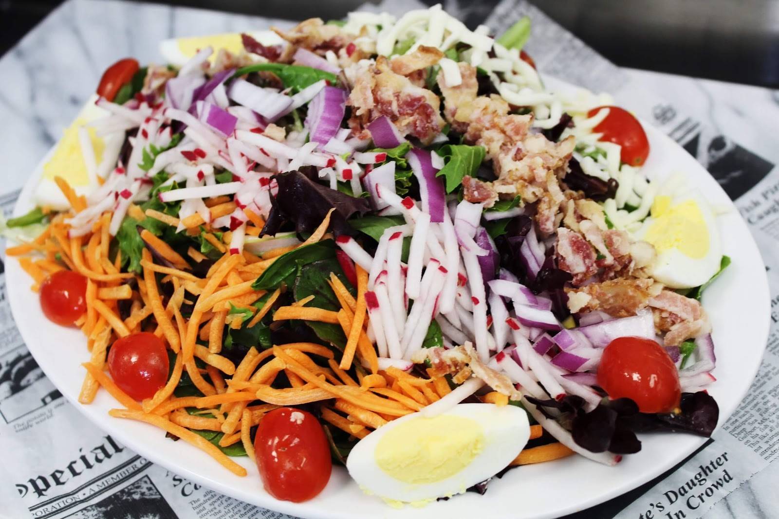 Salad with red onions, cherry tomatoes, carrots, and boiled eggs