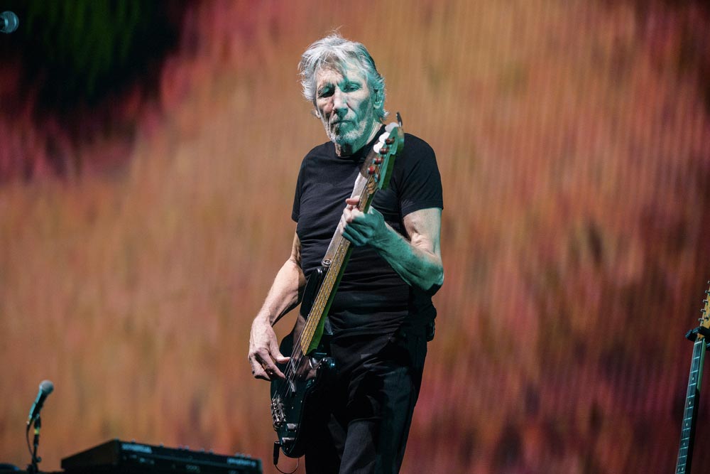 Člen kapely Pink Floyd Roger Waters koncertující s kytarou.