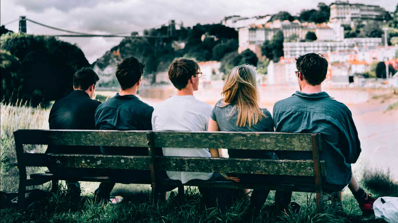 Entenda as Principais Mudanças nas Relações Afetivas do Futuro - Amigos sentados em banco vendo a cidade