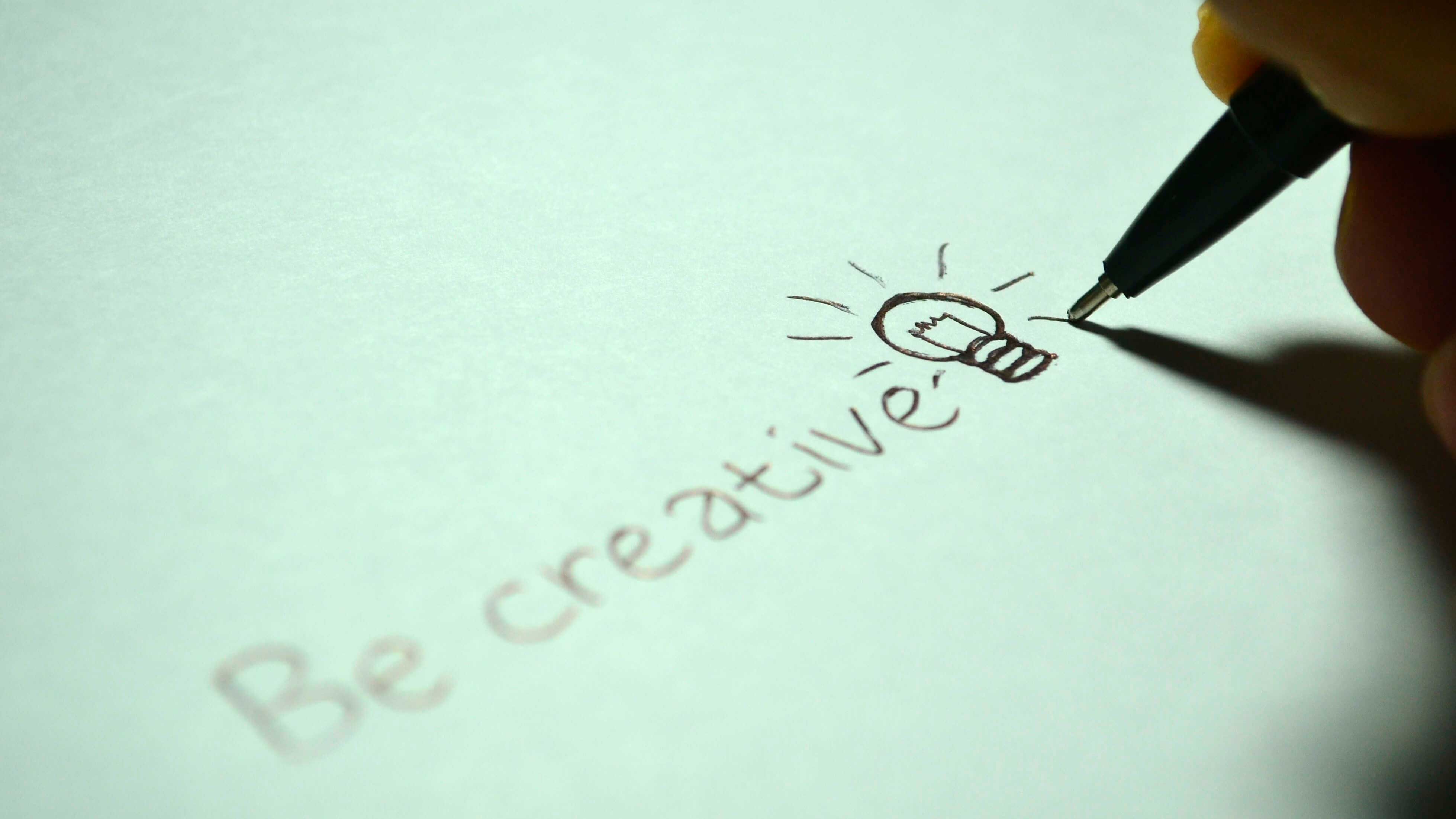 Caneta escrevendo "Be Creative"