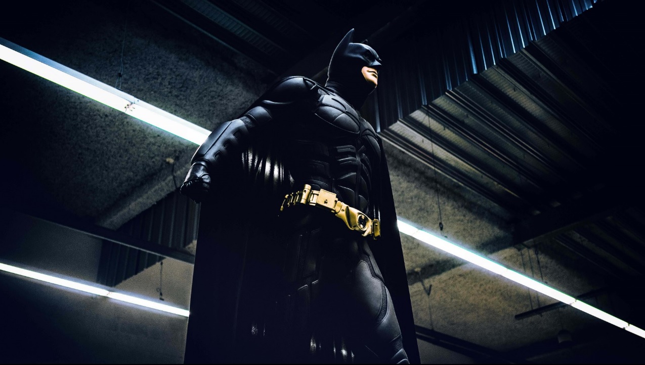 Estátua do Batman em pé em um ambiente escuro