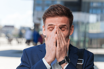 Young man rubbing his face with both hands because of sinus pressure.