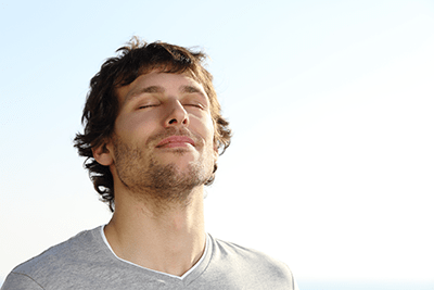 Young man outside, breathing deeply after the Open Procedure.