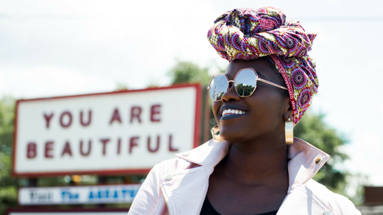 Woman in front of a sign "You are beautiful"