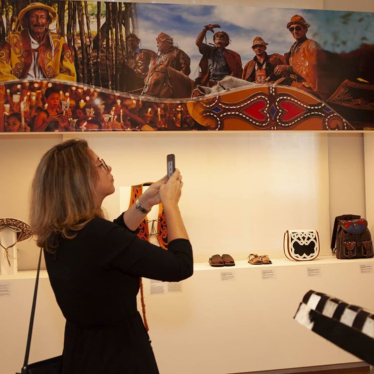 Festival Artesol, mulher fotografa sala com objetos feitos de couro por mestres artesãos brasileiros
