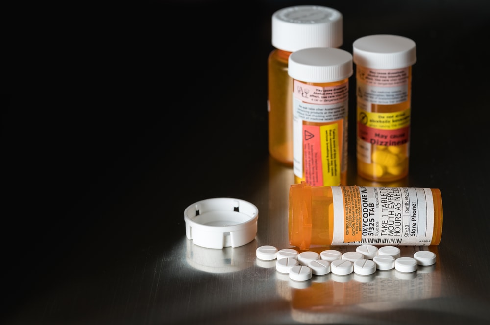 Opioid prescription pills on black surface