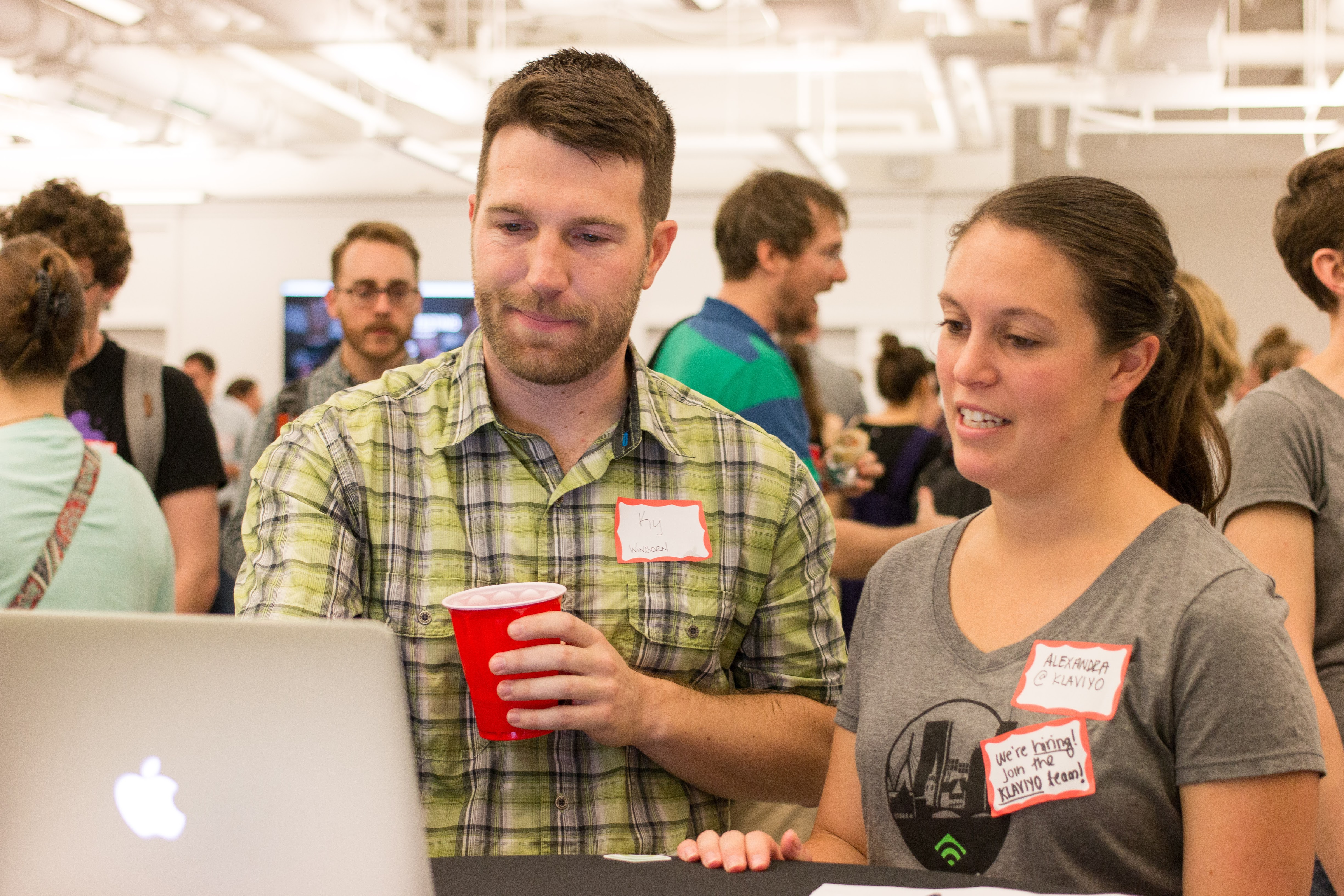 A man tests a product on a computer while a user researcher looks on