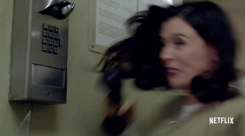 GIF of woman hitting a phone receiver against a wall