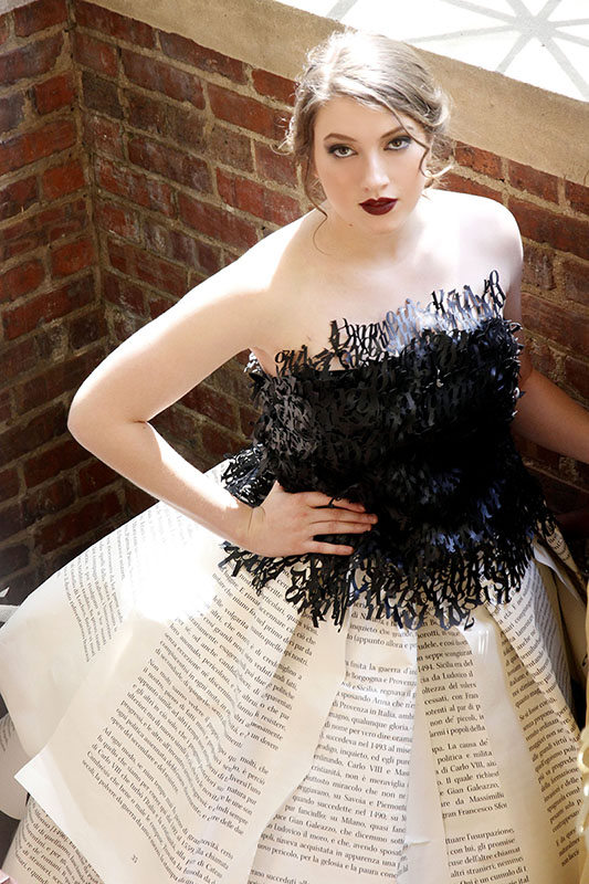 Model in leather typography top and giant book pages as a skirt.