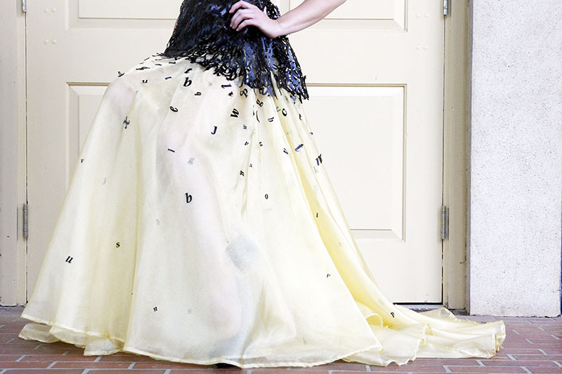 Long golden skirt and letters scattered down.