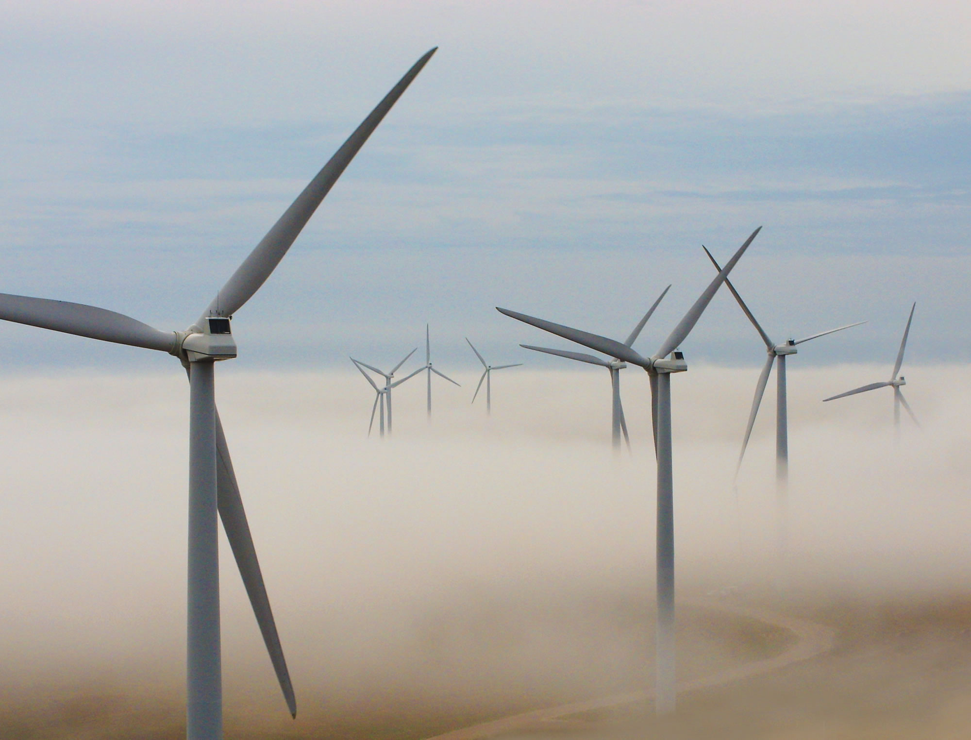 Wind turbines peaking through the clouds