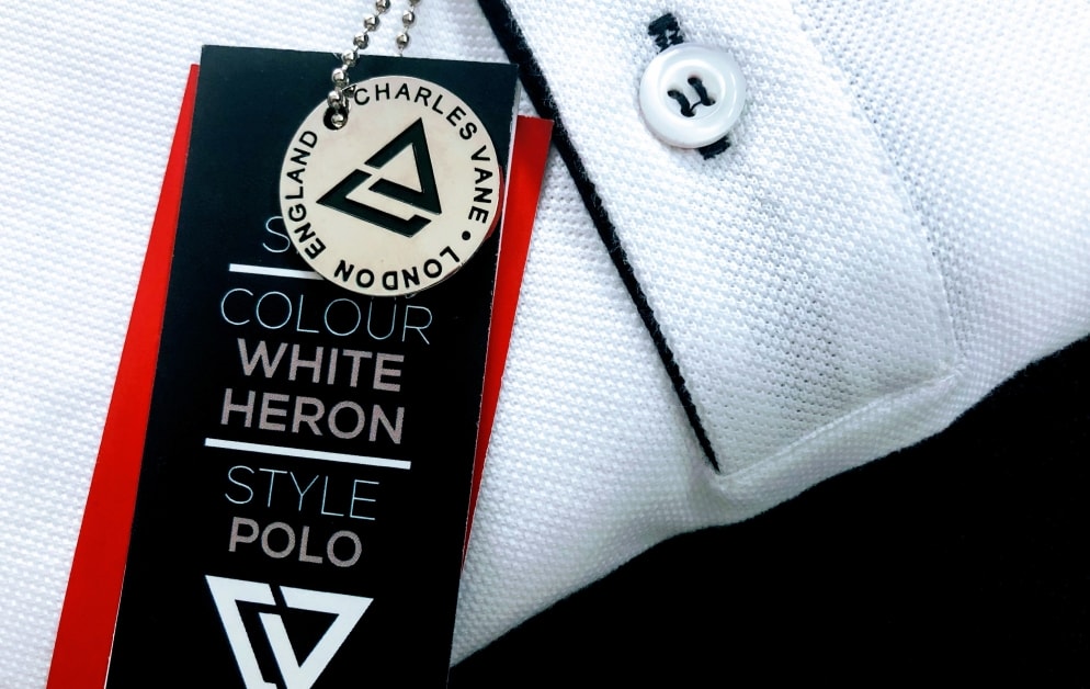 close up of folded charles vane white heron polo shirt with clothes tag.