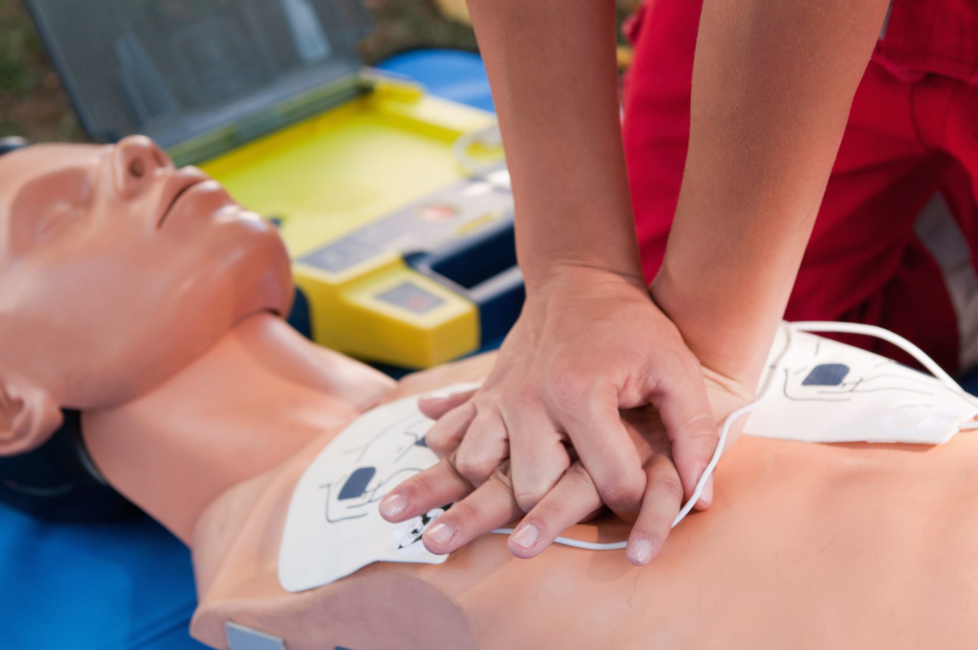 Students practicing chest compression techniques on a CPR dummy.