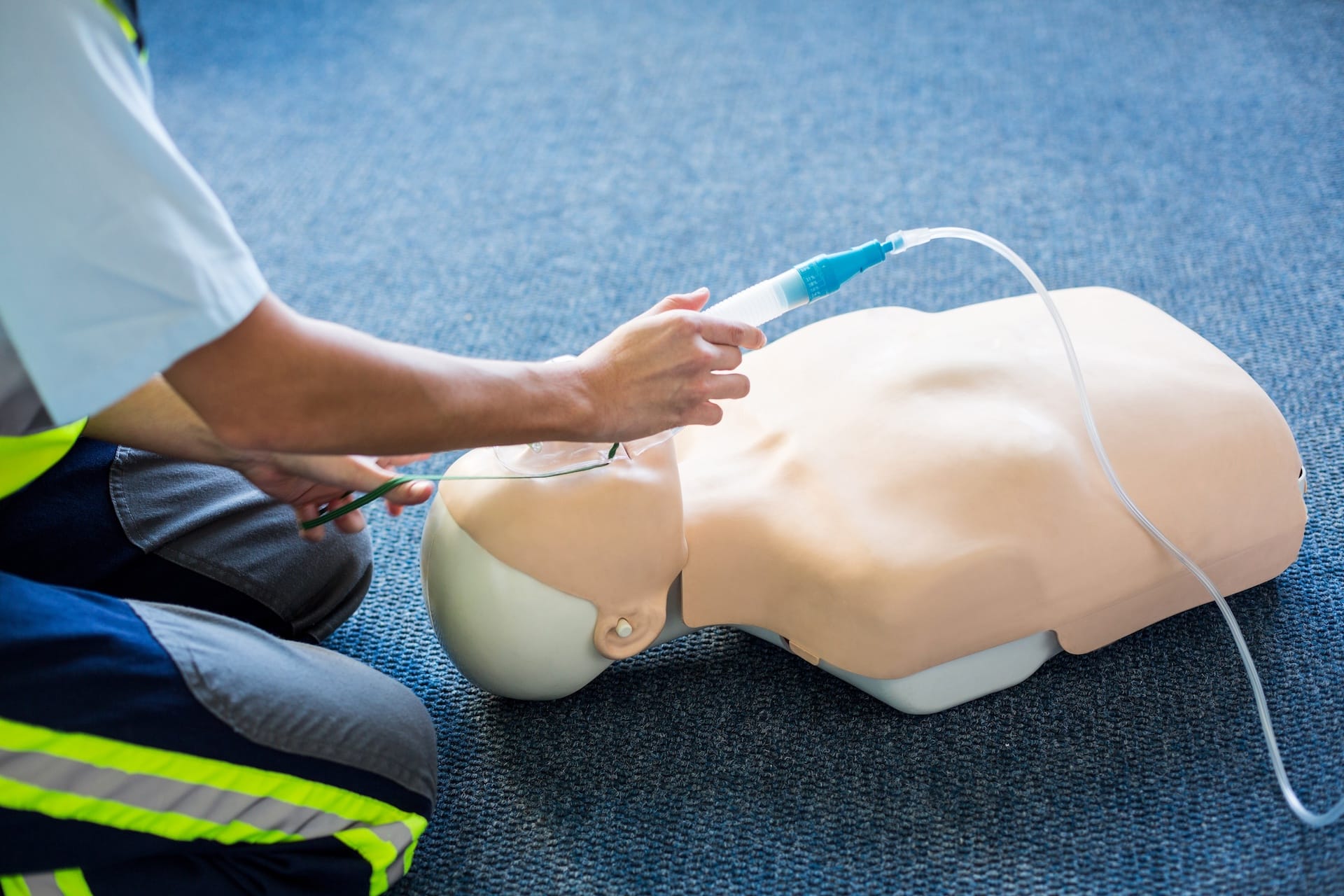 A student practicing proper fit of an emergency oxygen mask.