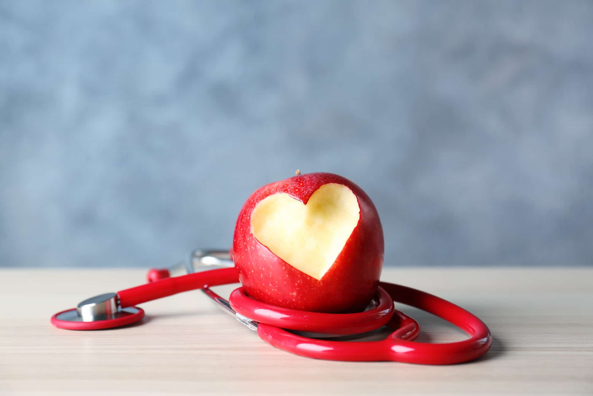 Stethoscope wrapped around a red apple.