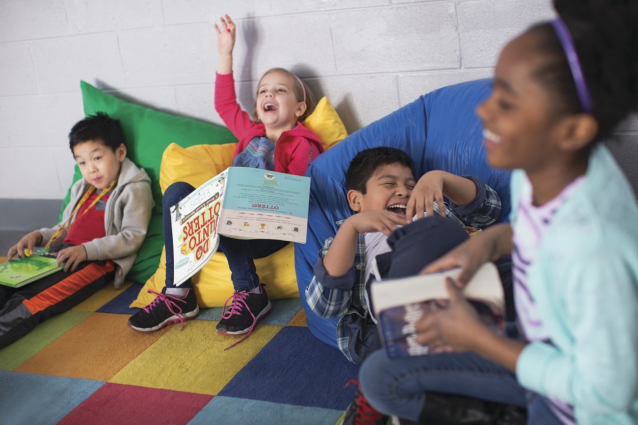 Kids on bean bags acting out a story from a book.