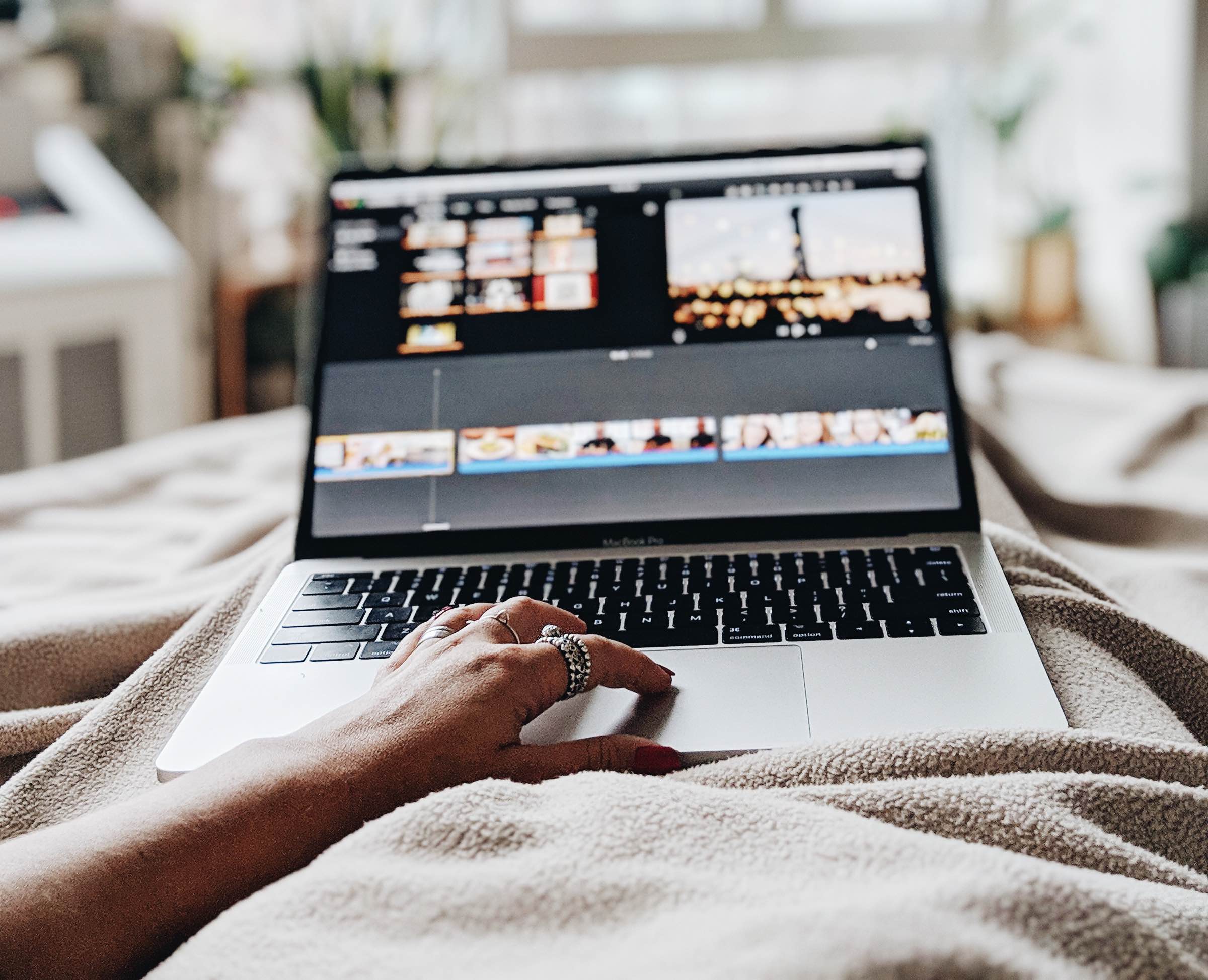 zestful blog image of female employee hand resting on macbook trackpad with video software on screen