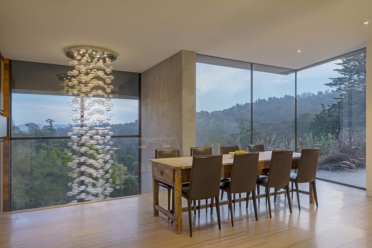 Designed for a tech entrepreneur couple and their young twins, the home in Mill Valley, California is a modern composition in articulated form. Located on a large wooded canyon site and sharing the land with a family of nesting red-tail hawks, this residence is designed to integrate into the landscape through cascading forms and natural materials. The exterior is a montage of natural wood, oxidized steel, and rich zinc panels blending with the surrounding foliage with many of these materials utilized on the interiors as well blurring the lines between inside and out. The main feature of the house is an observatory for the nesting raptors in the tree above visible through the upper level roofs to connect the interior to the beautiful natural surroundings.