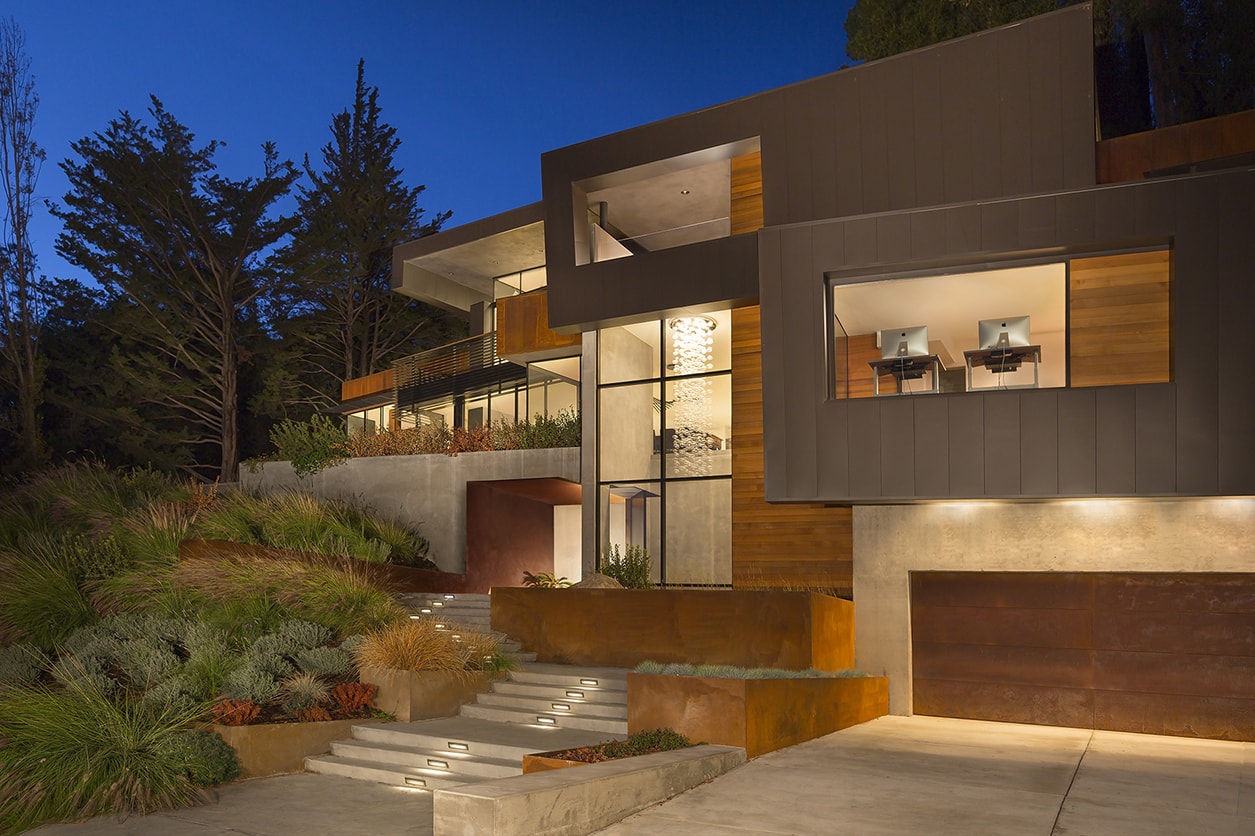 Designed for a tech entrepreneur couple and their young twins, the home in Mill Valley, California is a modern composition in articulated form. Located on a large wooded canyon site and sharing the land with a family of nesting red-tail hawks, this residence is designed to integrate into the landscape through cascading forms and natural materials. The exterior is a montage of natural wood, oxidized steel, and rich zinc panels blending with the surrounding foliage with many of these materials utilized on the interiors as well blurring the lines between inside and out. The main feature of the house is an observatory for the nesting raptors in the tree above visible through the upper level roofs to connect the interior to the beautiful natural surroundings.