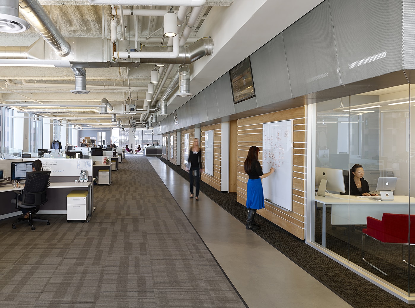 QA was commissioned to design the new corporate headquarters for New Relic, the fast-growing industry leader in Data Analytics for App Monitoring. Custom pen Collaborative Areas are located in the floor’s corners for quick informal meetings and impromptu mini-workstations for staff visiting other departments. The most dynamic space within the four full floors of offices is the large Café and All Hands Area that accommodates informal meetings, all-office presentations, and interactive interoffice social functions. The palette for New Relic was derived from the image invoked by its name- the juxtaposition of old and new, modern and decayed. Using reclaimed old growth elm, the wood is mingled amongst flamed steel walls, perforated metal panels and colorful furniture to create a warm, lively, and inviting work place. We are honored and excited that our design for the New Relic Headquarters was selected by the SF Business Times as one of the top "10 Coolest Offices in the Bay Area 2018."