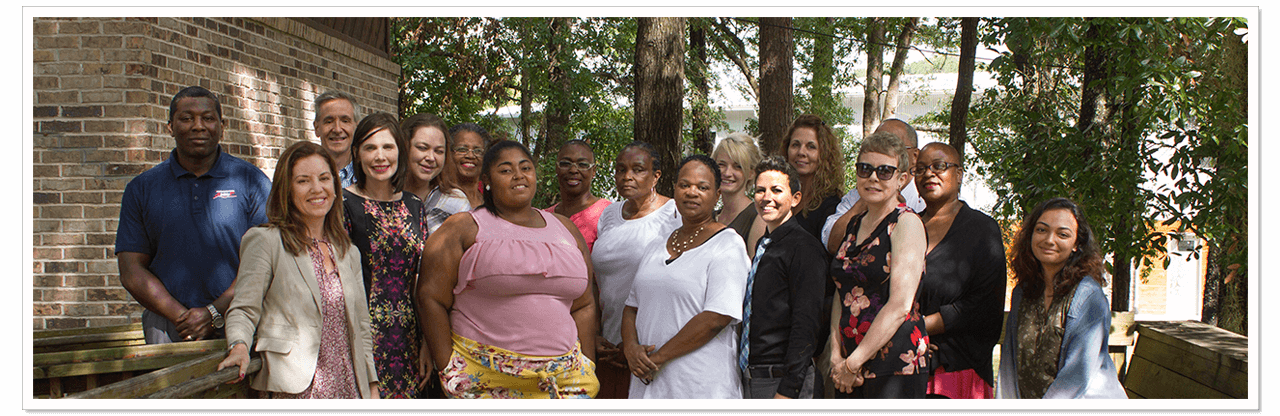 The staff of Ability1st, a diverse group of people including many with visible and invisible disabilities standing on the ramp in front of our office.