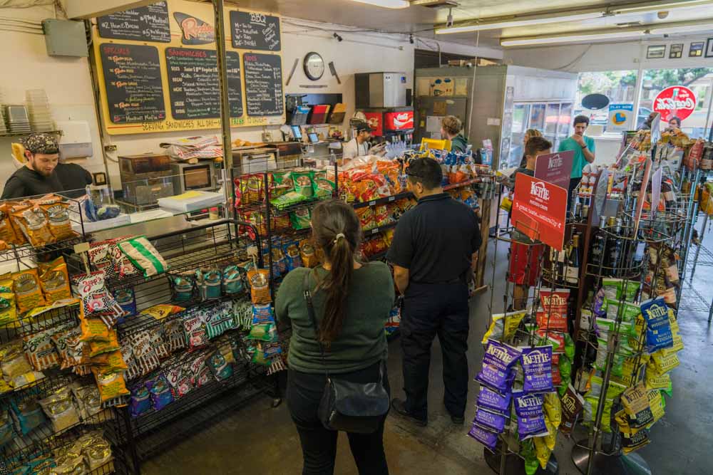 Patrons order sandwiches for lunch at the counter of Roxie Deli in East Sacramento for Visit Sacramento.