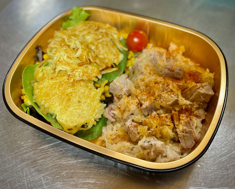 Kasseler Rippchen (smoked pork) with sauerkraut at the Adirondack Alps Restaurant in an oven-safe takeout container.
